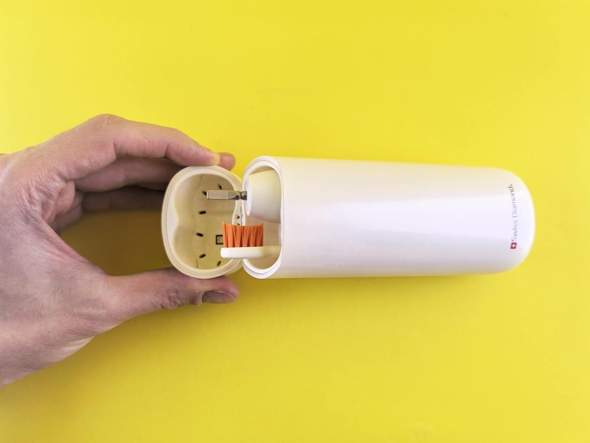 A stylish portable electric toothbrush with a sleek protective case against a vibrant yellow backdrop.